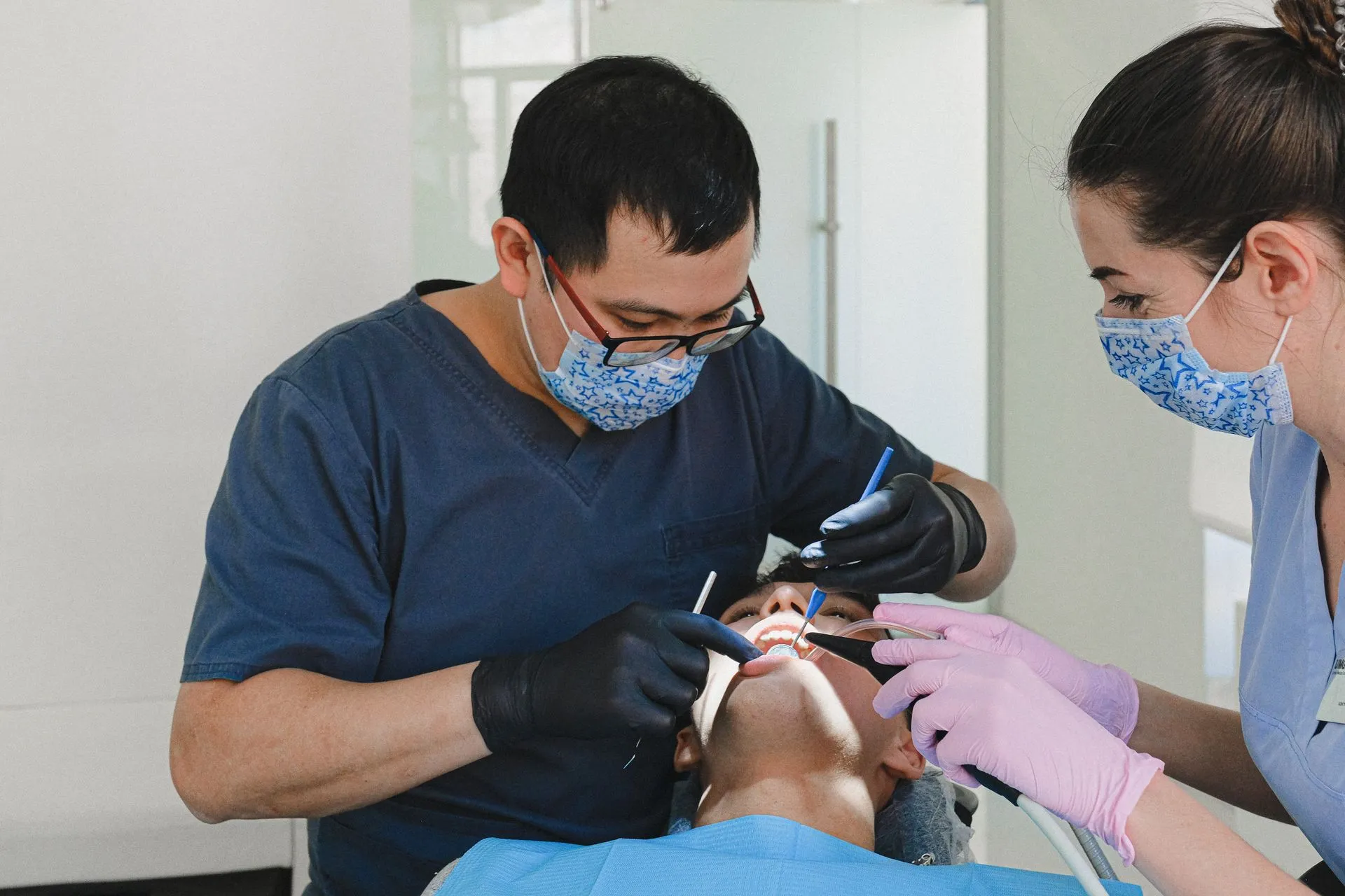 Dos dentistas realizando una revisión dental a un paciente en la consulta